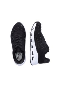 Baskets noires avec des clous décoratifs, tige en tissu texturé et semelle intermédiaire blanche contrastante. Forme arrondie avec lacets et col rembourré.