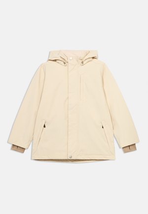 Veste imperméable beige avec capuche, fermeture éclair frontale recouverte d'un rabat à boutons-pression, deux poches latérales, et poignets intérieurs côtelés pour plus de chaleur.