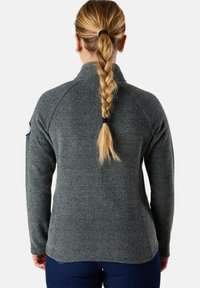 Grå, texturerad zip-up-tröja med hög krage och långa ärmar; har ett logomärke på vänster ärm. Slät tyg, figurnära design.