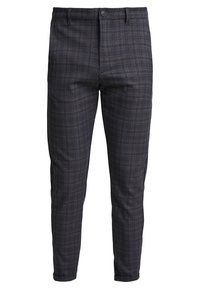 Donkergrijze geruite broeken met een gladde textuur, slim fit, riemlussen, voorste knoopsluiting en taps toelopende pijpen. Horizontale en verticale lijnen vormen een ruitpatroon.