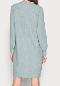 Abito maglione blu chiaro, texture lavorata a maglia, maniche lunghe, polsini e orlo a costine, lunghezza al ginocchio, tessuto morbido, vestibilità relax.