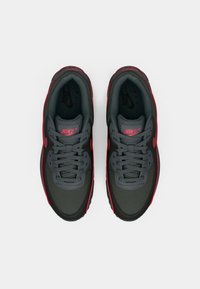 Par crni i crveni Nike Air tenisica s gledišta odozgo na bijeloj pozadini s vidljivim vezicama i brendiranjem.