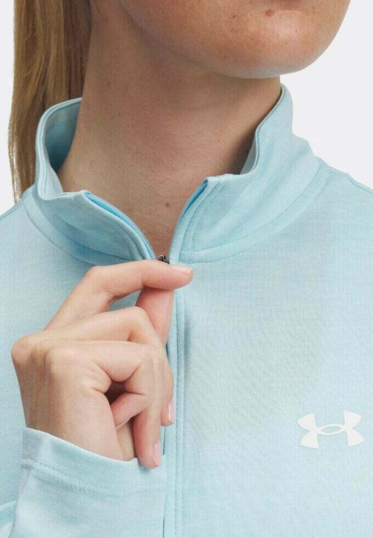 Helleblaue Zip-Jacke mit hohem Kragen, aus glattem Stoff gefertigt. Verfügt über ein weißes Logo auf der linken Seite und einen halben Reißverschluss.