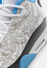 Sneakers featuring a white leather upper with intricate brown patterns, black midsole, light blue accents, and white laces.