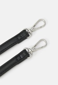 Cinturino in pelle nera con una texture liscia e clip in metallo argentato a entrambe le estremità per il fissaggio. Presenta dettagli di cucitura lungo i bordi.