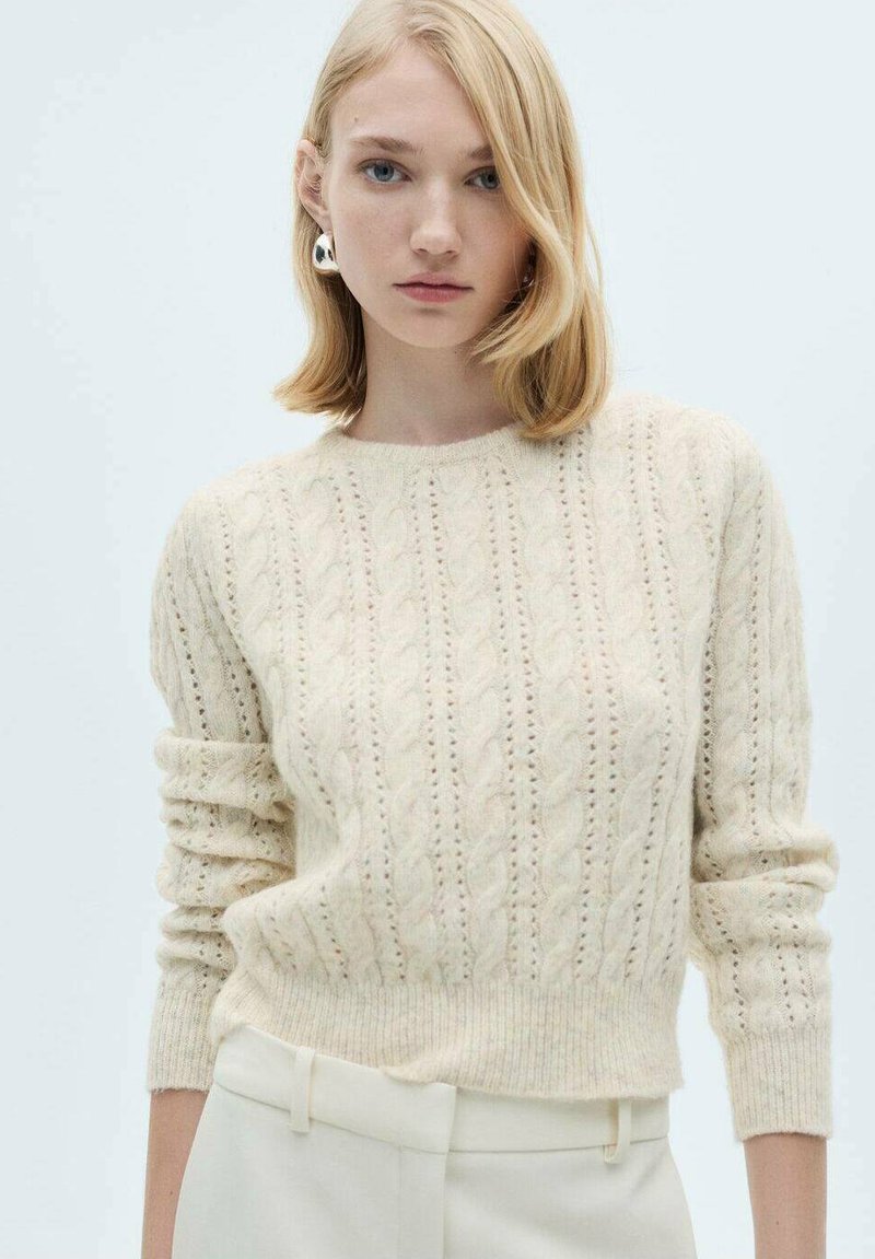 Cremfarbener Strickpullover mit Zopfmuster, geripptem Ausschnitt und Bündchen sowie einem leicht verkürzten Schnitt. Sanfte Textur.