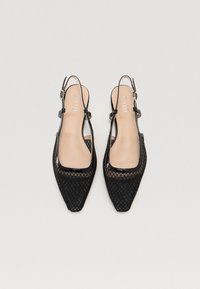 Talons aiguilles noires à bride arrière avec une tige en résille et une finition brillante en vernis noir. Sangle à boucle réglable incluse.