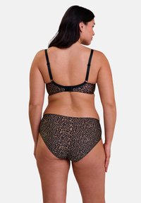 Ensemble de lingerie imprimé léopard avec un schéma de couleurs noir et beige. Bretelles réglables sur le soutien-gorge et culotte taille haute assortie.