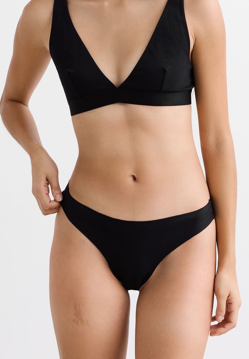 Ensemble de bikini noir comprenant un bralette à décolleté en V avec des larges bretelles et un bas de bikini taille basse assorti, fabriqué en tissu lisse et extensible.