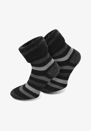 Schwarz- und grau gestreifte Socken mit einem flauschigen schwarzen Bund. Der Stoff wirkt weich und strukturiert, ideal für Wärme und Komfort.