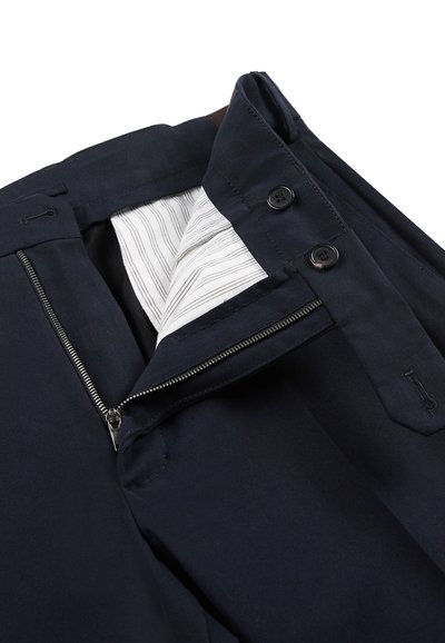 Pantaloni navy con zip e chiusura a bottone, foderati con un interno a righe. Presentano dettagli cuciti e un materiale misto cotone resistente.