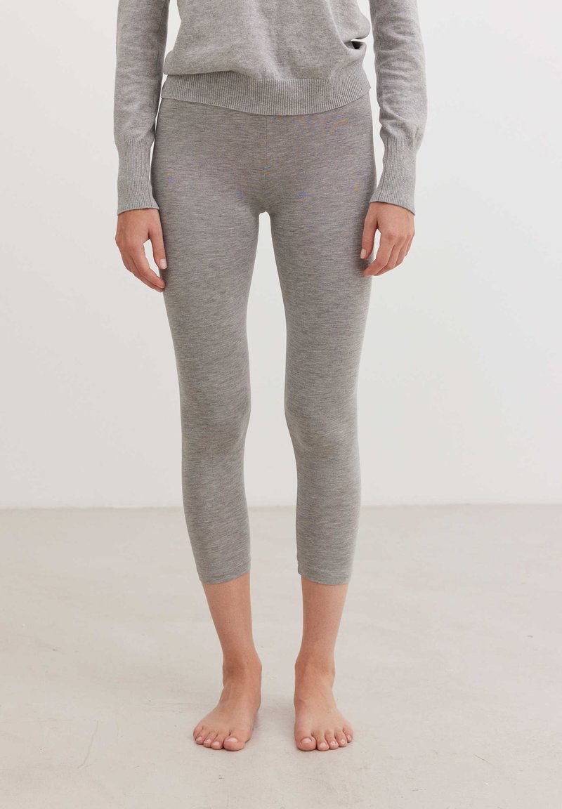Leggings de algodón gris con una cinturilla acanalada, de longitud 3/4, con una textura suave y un diseño sencillo, aptos para un uso casual.