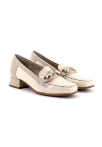 Mocasines de charol beige con un pequeño tacón cuadrado. Presentan un accesorio decorativo de cadena en el empeine y paneles laterales texturizados en contraste.