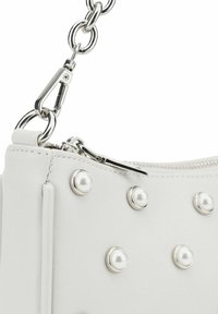 Borsa sintetica bianca con chiusura a zip, accessori in argento e dettagli borchiati. Spallaccio a catena attaccato per una maggiore comodità nel trasporto.