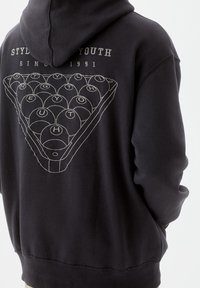 Sudadera negra con capucha que presenta un gráfico de triángulo con bolas de bilar y el texto "STYLISH YOUTH" y "SINCE 1991" en contorno blanco en la parte posterior.
