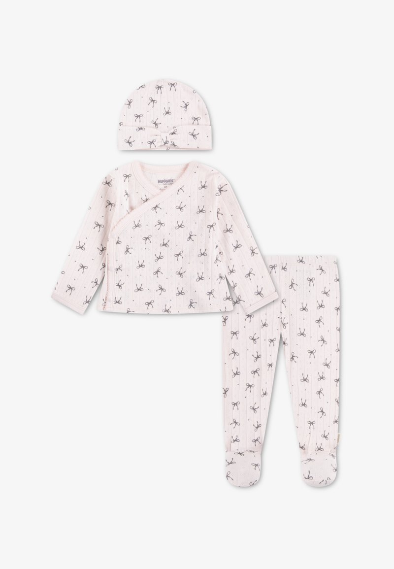 Ensemble bébé en coton blanc avec fond rose clair, orné de motifs de nœuds gris, comprenant un haut cache-cœur à manches longues, un pantalon et un chapeau assorti.