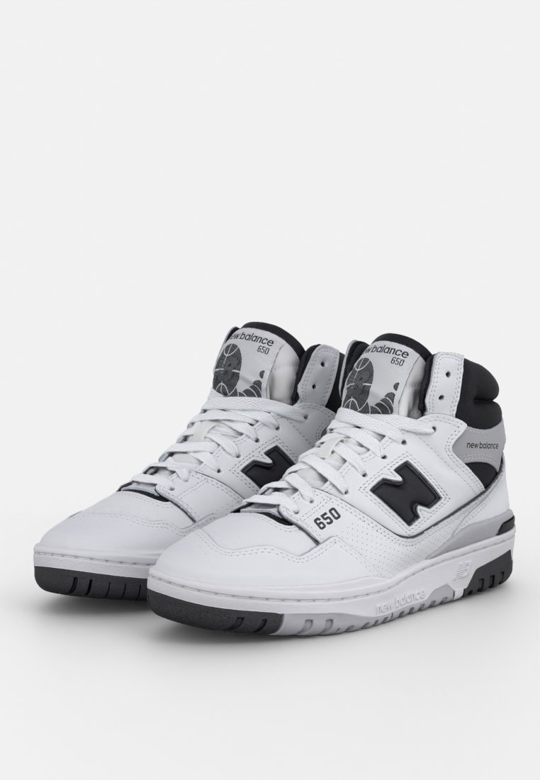 Baskets montantes blanches en cuir, avec des accents noirs, des panneaux perforés et une semelle grise portant la marque '650' et 'new balance'.