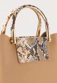 Borsa a tracolla marrone con texture, caratterizzata da un flap in stampa serpente, hardware in tono oro e doppi manici rivestiti in un materiale decorato.