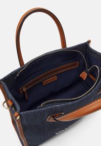 Öppen marinblå denim toteväska med bruna läderhandtag, inre dragkedjeficka och "Mario Valentino"-etikett inuti.