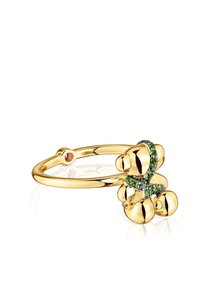 Anello in oro con design a forma di orsetto, decorato con gemme verdi e nere, caratterizzato da forme morbide e arrotondate e una finitura lucida.