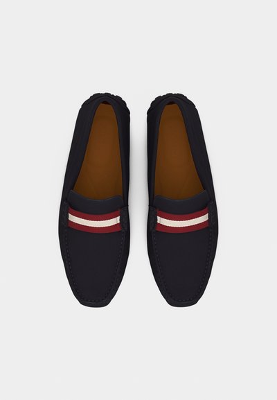 Mocassins noirs à bouts carrés arrondis avec des bandes rayées rouges et blanches sur le dessus, vus de dessus sur un fond blanc.