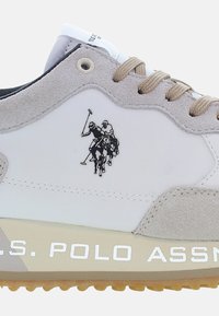 White sneaker with grey suede accents and a rubber sole. Features a horse polo logo and "U.S. POLO ASSN." text on the side.