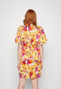 Robe florale avec des motifs vibrants de jaune, rose et rouge. Manches courtes, taille cintrée et ourlet au genou. Tissu lisse avec une texture douce.