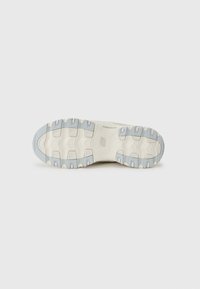 Sneaker outsole featuring a textured rubber surface with deep grooves, in cream and light blue colors, designed for traction and durability.