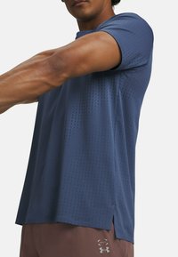 T-shirt de sport navy à manches courtes, avec de petites perforations sur l'ensemble pour la respirabilité et une coupe droite avec des fentes sur les côtés.