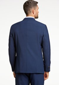Chaqueta de traje azul marino con un corte suave y ajustado. Presenta una abertura trasera, solapas elegantes y detalles de botones en los puños.