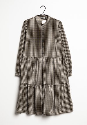 Robe à carreaux noirs et beiges avec un col montant, des manches longues, une fermeture boutonnée sur le devant et un ourlet à volants étagés, confectionnée dans un tissu léger.