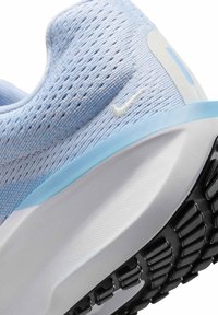 Sneaker azzurro chiaro con tomaia a maglia traspirante, logo Nike bianco e suola in gomma nera texturizzata per una migliore aderenza.