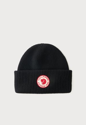 Gorro de punto negro con canalé, puño doblado y un parche redondo blanco y rojo con el logo de Fjällräven Sweden 1960 en el frente.