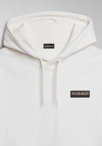 Sweat à capuche blanc avec cordons, présentant un petit patch logo noir Napapijri Geographic sur la poitrine et une étiquette à l'intérieur de la capuche.