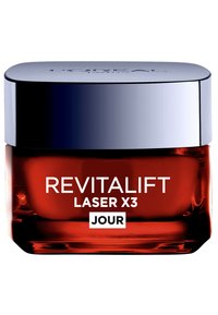 Le pot de crème Revitalift Laser X3 a une base en verre rouge brillant, un couvercle en argent et un texte blanc. Le design est moderne avec une forme lisse et arrondie.