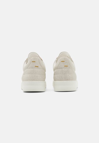 Beige Sneaker mit einer strukturierten Wildleder-Oberfläche, ausgestattet mit einer weißen Gummisohle und minimalistischem Design, das klare Linien und subtile Akzente hervorhebt.