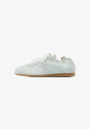 Baskets en daim gris clair avec lacets blancs et détails perforés sur le côté, semelle en caoutchouc beige, vues de profil sur fond blanc.