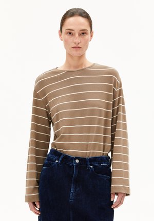 Bruine langemouwen top met witte horizontale strepen. Zachte stof, relaxte pasvorm, ronde hals. Gecombineerd met blauwe corduroy broek met knoopsluiting.