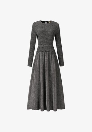 Zwarte jurk met lange mouwen, gesmockte lijfje, uitlopende rok en een gestructureerde, glinsterende afwerking. Open rug met keyhole-detail zorgt voor extra uitstraling.