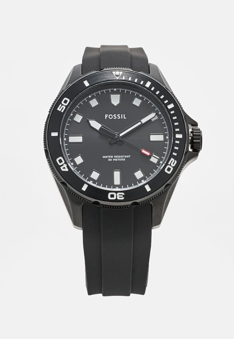 Fossil Uhr mit schwarz rundem Zifferblatt, leuchtenden Markierungen und Zeigern; wasserdicht bis 50 Meter; Silikonarmband; kräftige kontrastierende weiße Akzente.