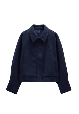 Granatowa, skrócona kurtka z mieszanki wełny, z dużym kołnierzem, bocznymi kieszeniami oraz prążkowanymi detalami na dole i przy mankietach.