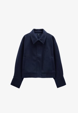 Granatowa, skrócona kurtka z mieszanki wełny, z dużym kołnierzem, bocznymi kieszeniami oraz prążkowanymi detalami na dole i przy mankietach.