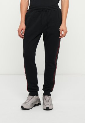BANDA ALANZ - Pantalones deportivos - black/red/white