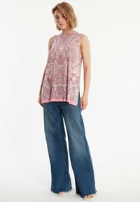 Roze paisley mouwloze top met een relaxte pasvorm, voorzien van zijsplitten en een gladde textuur, gecombineerd met wijde blauwe denim jeans.