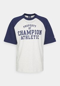Šedé tričko s krátkým rukávem s námořnickými raglánovými rukávy a textem "MAJETEK CHAMPION ATHLETIC" v tučných námořnických písmenech.