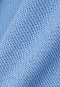 Hellblauer Stoff mit einem strukturierten, gestrickten Muster; dicht gewebt mit einer dezenten, weichen Oberfläche. Ideal für Kleidung oder Polsterung.