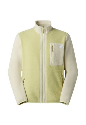 Fleecová bunda v světle zelené a krémové barvě se zipem vpředu, vysokým límcem, dvěma bočními kapsami a kapsou na hrudi. Má zipy a logo.