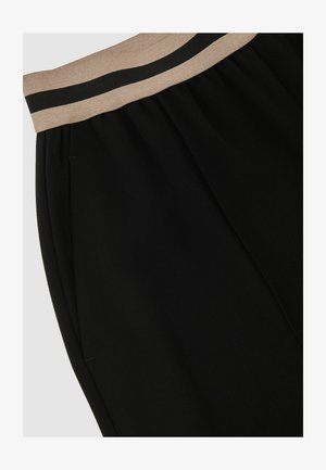 Melnas bikses ar elastīgu jostasvietu un gaiši brūnu un tumšu svītrojumu detaļā. Mīksta tekstūra ar sānu šuvēm un bez redzamām kabatām.