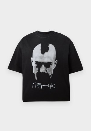 Μαύρο oversized t-shirt με λευκό αφηρημένο γραφικό προσώπου και στυλιζαρισμένο κείμενο κάτω από αυτό στο μπροστινό μέρος.