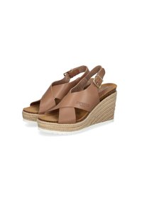 Tan leather wedge sandals with cross-strap design and adjustable buckle. Jute-wrapped platform and white rubber outsole for traction.
